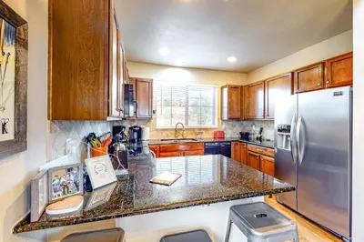 a kitchen with wooden cabinets and a stainless steel refrigerator at Summit Point Place in Granby