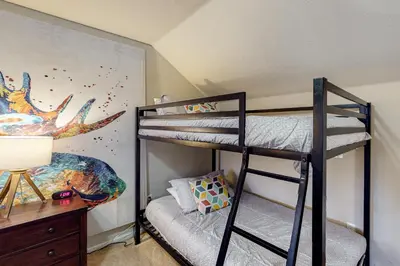 a bedroom with two bunk beds and a desk at Summit Point Place in Granby