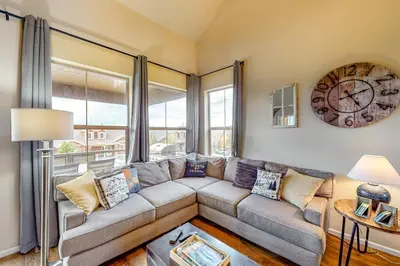a living room with a couch and a clock on the wall at Summit Point Place in Granby