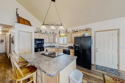 a kitchen with a counter and a black refrigerator at Hemlock Cabin in Granby