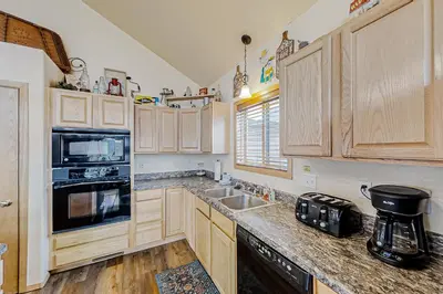 a kitchen with wooden cabinets and a sink at Hemlock Cabin in Granby