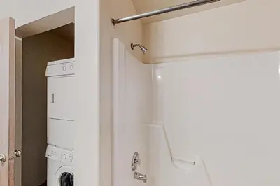 a white washer and dryer in a bathroom at Hemlock Cabin in Granby