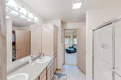 a bathroom with two sinks and a shower at Hemlock Cabin in Granby
