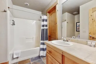 a bathroom with a sink and a tub and a shower at The Antlers 401 in Winter Park