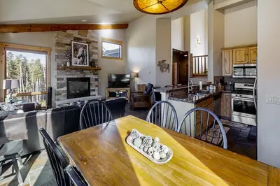 a kitchen and living room with a wooden table and chairs at The Antlers 401 in Winter Park