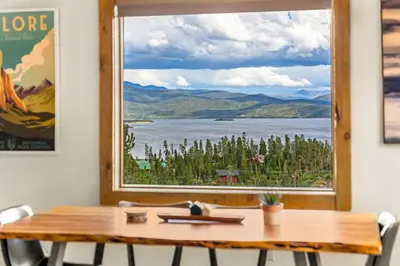 a table with a view of a lake and mountains at Infinity View in Grand Lake