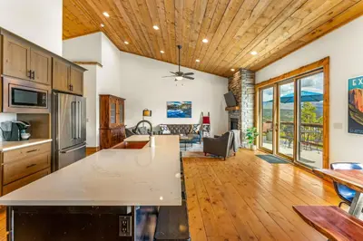 a kitchen and living room with a wooden ceiling at Infinity View in Grand Lake