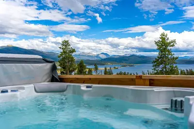 a hot tub with a view of a lake and mountains at Infinity View in Grand Lake