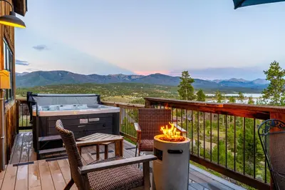 a patio with a hot tub and a grill on a deck at Infinity View in Grand Lake