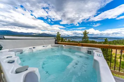 a hot tub on the balcony of a house at Infinity View in Grand Lake