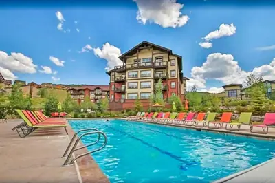 a pool with chairs and a building in the background at Sagebrush Cabin in Granby
