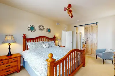 a bedroom with a wooden bed and a chair at Sagebrush Cabin in Granby