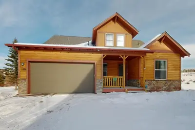 a house with a garage in the snow at Sagebrush Cabin in Granby