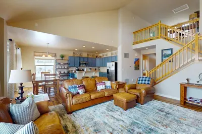 a living room with a couch and chairs and a kitchen at Sagebrush Cabin in Granby