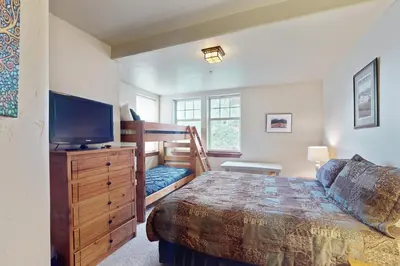 a bedroom with a bunk bed and a television at Cozens Pointe D201 in Fraser