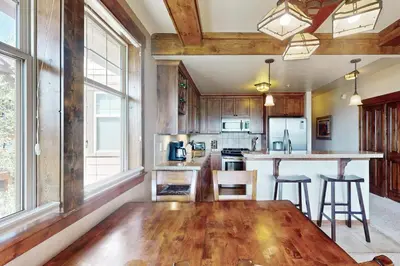 a kitchen with a wooden floor and a table at Cozens Pointe D201 in Fraser