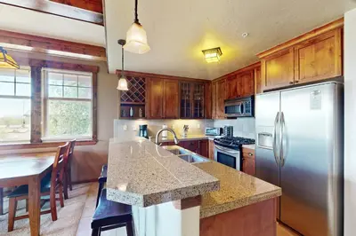 a kitchen with wooden cabinets and a stainless steel refrigerator at Cozens Pointe D201 in Fraser