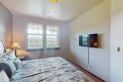a bedroom with a bed and a flat screen tv at Cozens Pointe D201 in Fraser
