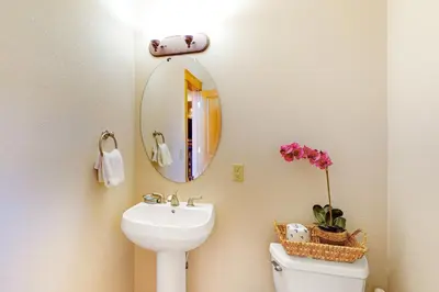 a bathroom with a sink and a mirror and a toilet at Red Quill Village in Winter Park