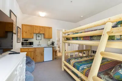 a room with two bunk beds and a kitchen at The Seasons 1834 condo in Keystone