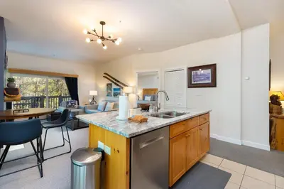 a kitchen with a sink and a living room at The Seasons 1834 condo in Keystone