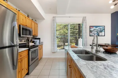 a kitchen with a stainless steel refrigerator and a sink at The Seasons 1834 condo in Keystone