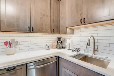a kitchen with wooden cabinets and a sink at Walk to Main St! Condo with Hot Tub and Pool in Frisco in Frisco