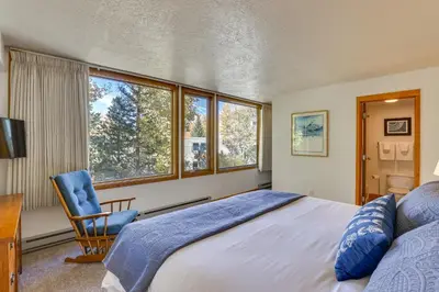 a bedroom with a bed and a chair and windows at 1 Mi to Keystone Ski Lift Lakefront 4-Season Gem in Dillon