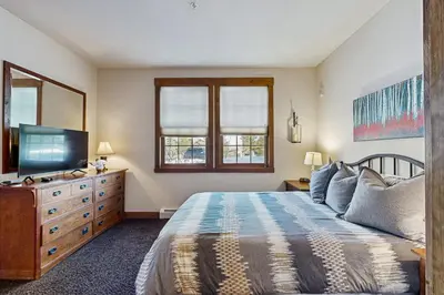 a bedroom with a bed and a flat screen tv at Bluebird Skies in Granby