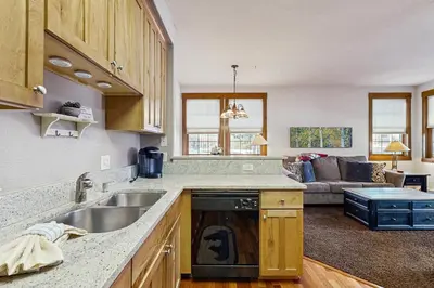 a kitchen with a sink and a couch in a living room at Bluebird Skies in Granby