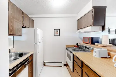 a kitchen with wooden cabinets and a white refrigerator at Wildernest Getaway in Silverthorne