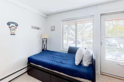 a bedroom with a blue bed and a window at Wildernest Getaway in Silverthorne