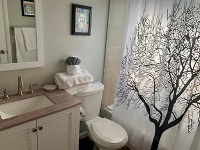 a bathroom with a shower curtain with a tree on it at Your home close to Anshutz and DIA in Aurora