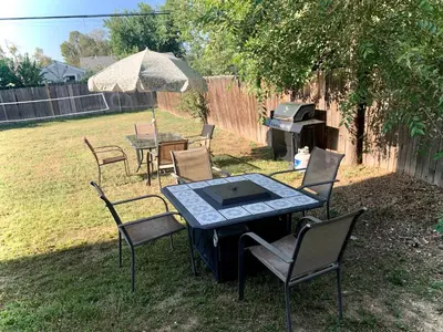 a table with chairs and a grill in a yard at Your home close to Anshutz and DIA in Aurora