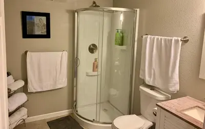 a bathroom with a shower and a toilet and towels at Your home close to Anshutz and DIA in Aurora