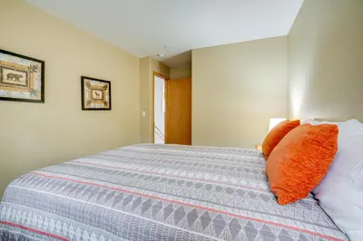 a bedroom with a bed with orange pillows on it at Silverthorne Gem with Community Perks 11 Mi to Ski! in Silverthorne