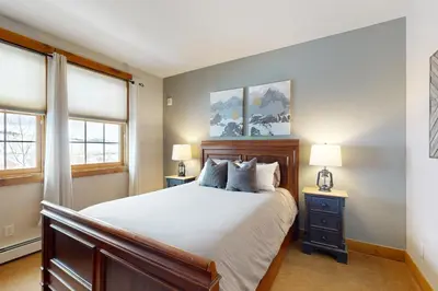 a bedroom with a large bed and two windows at Granby Grandeur in Granby