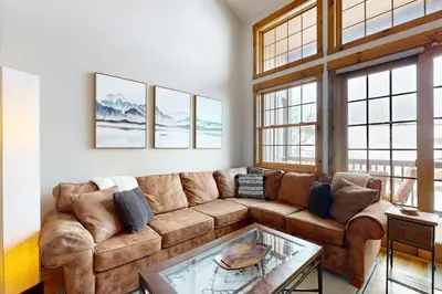 a living room with a couch and a glass table at Granby Grandeur in Granby