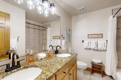 a bathroom with two sinks and a toilet at Granby Grandeur in Granby
