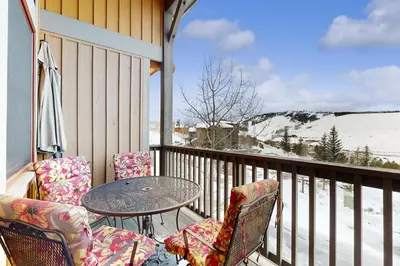 a patio with a table and chairs on a balcony at Granby Grandeur in Granby