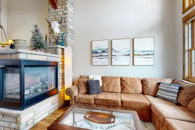 a living room with a couch and a fireplace at Granby Grandeur in Granby