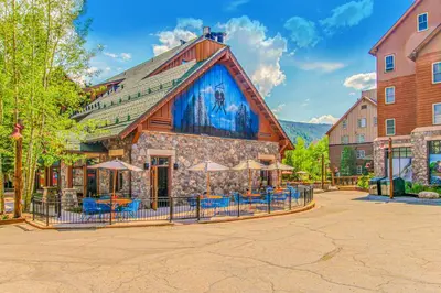 a building with chairs and umbrellas in front of it at Silvermill Lodge 8250 in Keystone