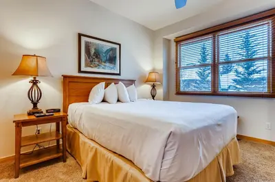 a bedroom with a large white bed and a window at Premiere 2Br Townhome - Shuttle to Slopes, Kids Ski Free! condo in Keystone