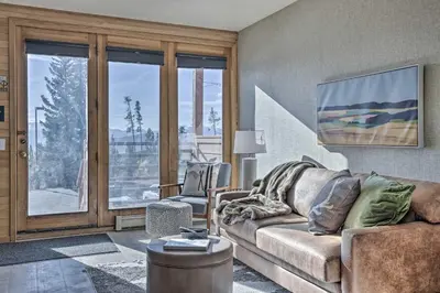a living room with a couch and a large window at Pool, Hot Tub and Ski Shuttle! Silverthorne Condo in Silverthorne