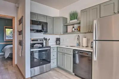 a kitchen with white cabinets and a stainless steel refrigerator at Pool, Hot Tub and Ski Shuttle! Silverthorne Condo in Silverthorne