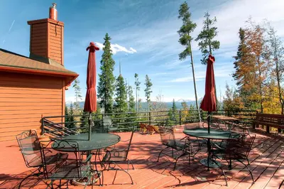 a patio with tables and chairs and red umbrellas at Pool, Hot Tub and Ski Shuttle! Silverthorne Condo in Silverthorne