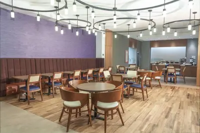 a dining room with tables and chairs under a chandelier at Hilton Garden Inn Broomfield Boulder in Broomfield