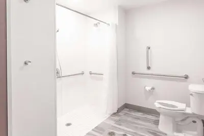 a white bathroom with a shower and a toilet at Hilton Garden Inn Broomfield Boulder in Broomfield