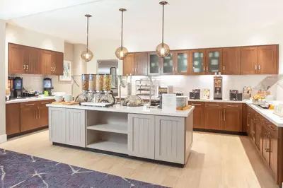 a large kitchen with wooden cabinets and a large island at Homewood Suites By Hilton Broomfield Boulder in Broomfield