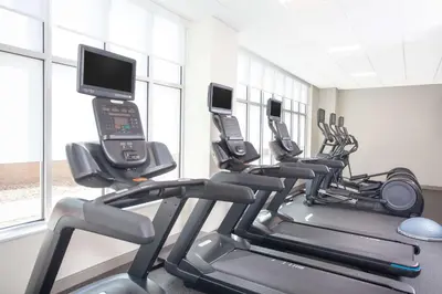 a gym with several tread machines with cell phones at Homewood Suites By Hilton Broomfield Boulder in Broomfield